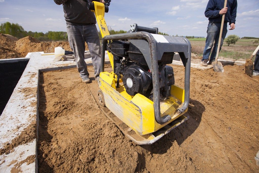 worker using a compactor