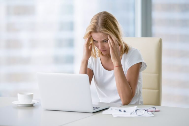 Woman experiencing a headache while working