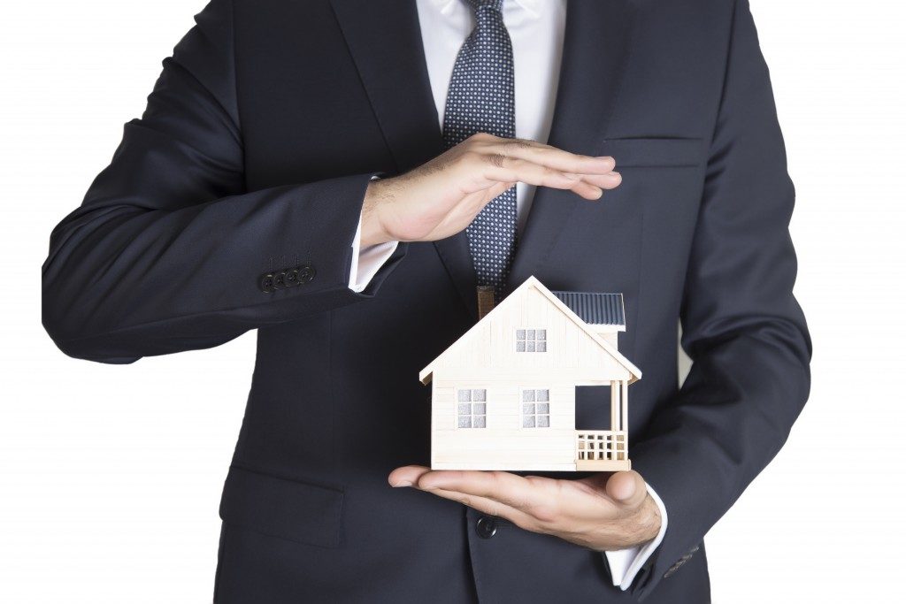 Real estate agent holding small model of a house