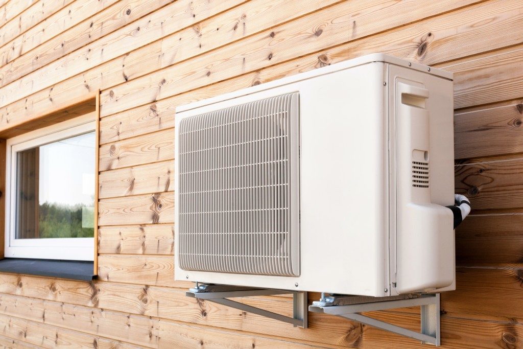 Exterior airconditioning unit mounted on wooden wall