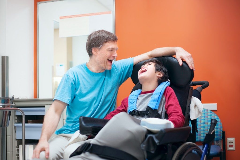 father laughing with his child with disability