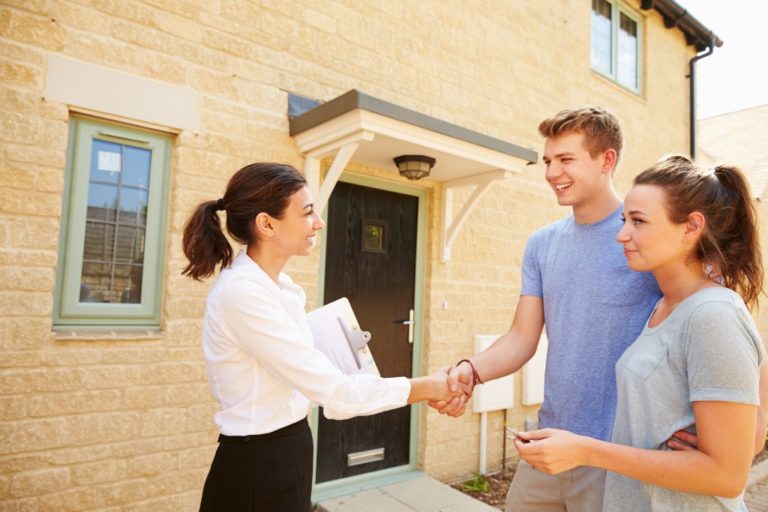 Couple shaking hands with the real estate agent