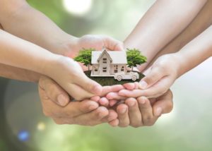 hands holding a house model