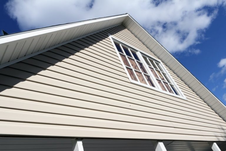 House exterior, against a blue sky. Roof close-up. Low angle view.