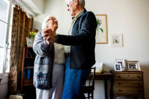 senior couple dancing in the living room