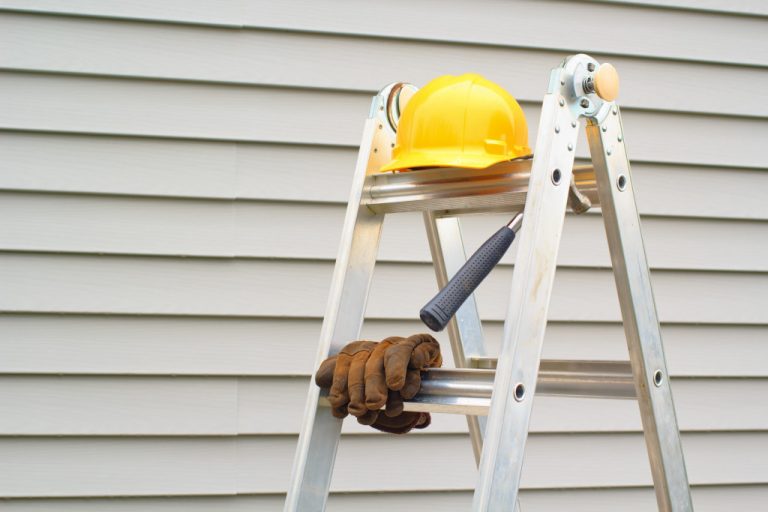 helmet, gloves, and hammer on a ladder