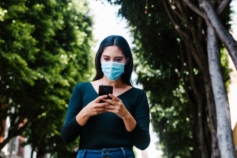 woman wearing a mask while texting