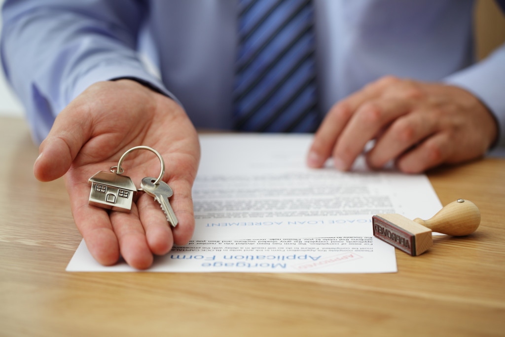 A seller hands over the keys to a new home after receiving a mortgage application form