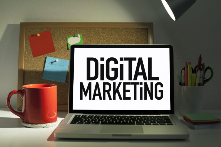 a laptop with digital marketing written on the screen and a mug beside it