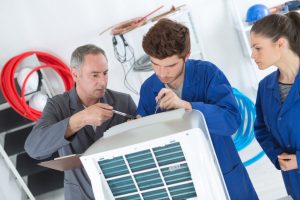 Maintenance personnel working on office AC