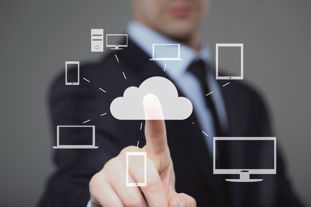 businessman touching a cloud icon representing cloud computing