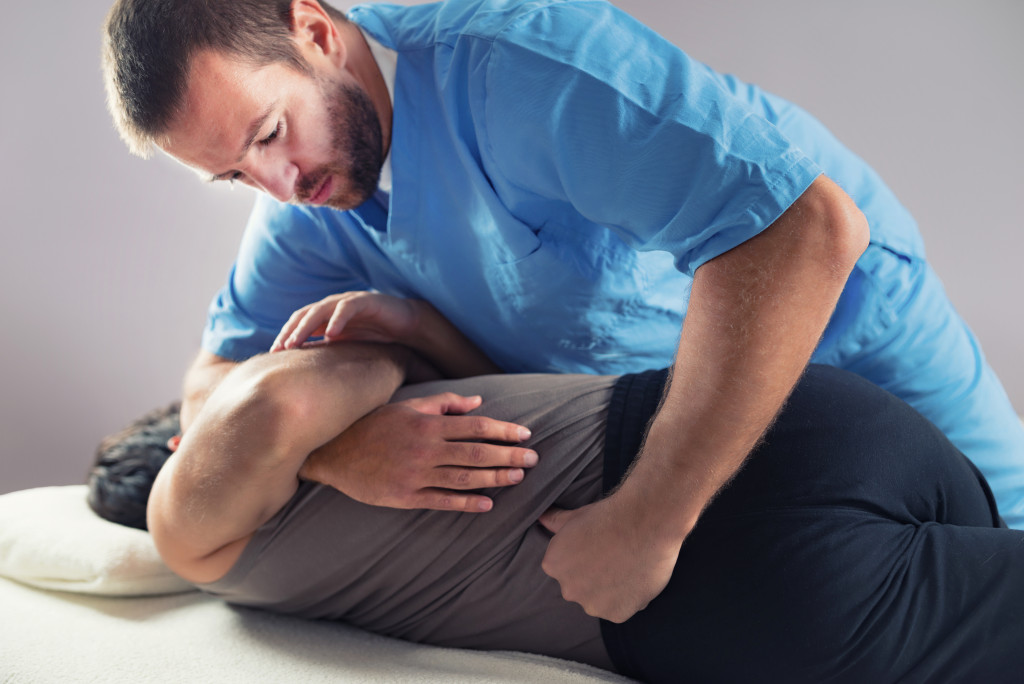 A physical therapist stretching a patient's back