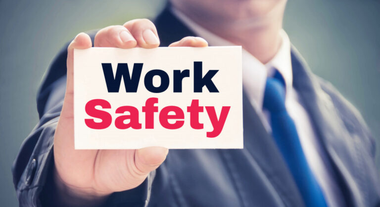 A businessman holding a card with Work Safety on it