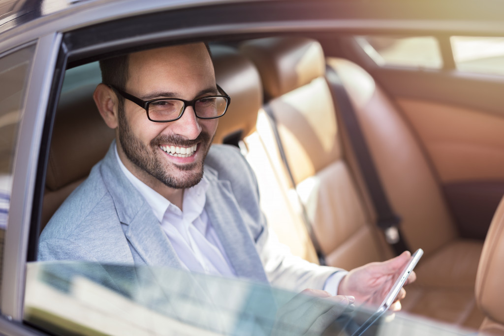smiling businessman in the car with leather seat