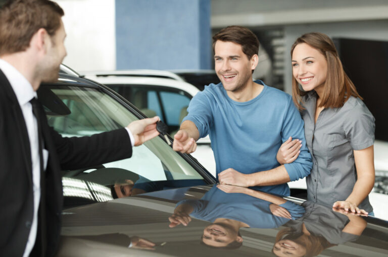 an agent handing car keys to a couple