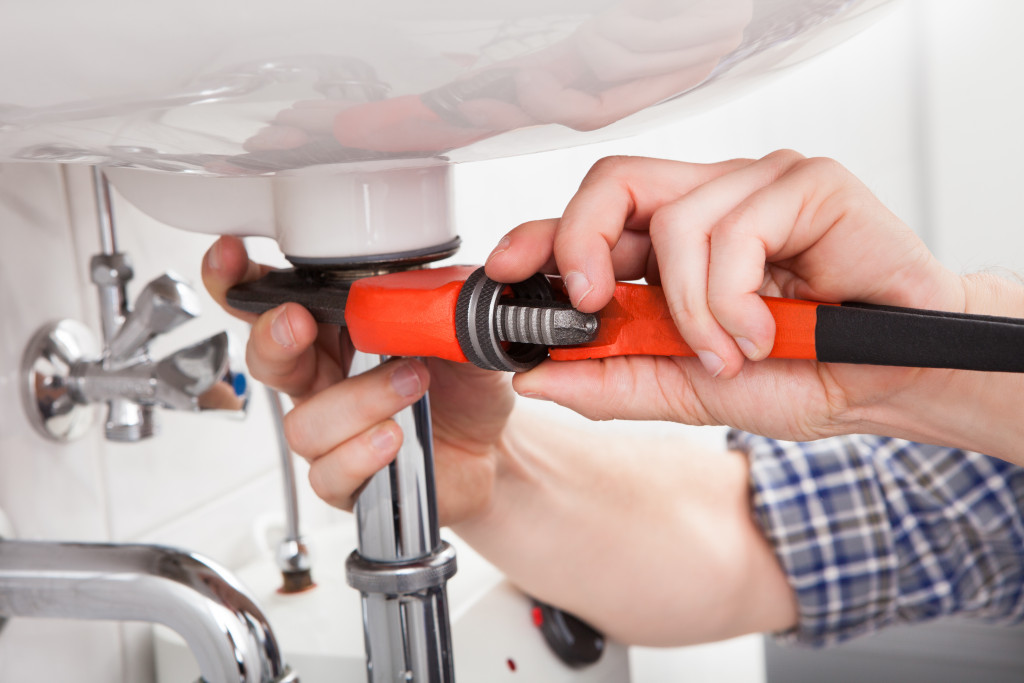 male plumber fixing bathroom sink