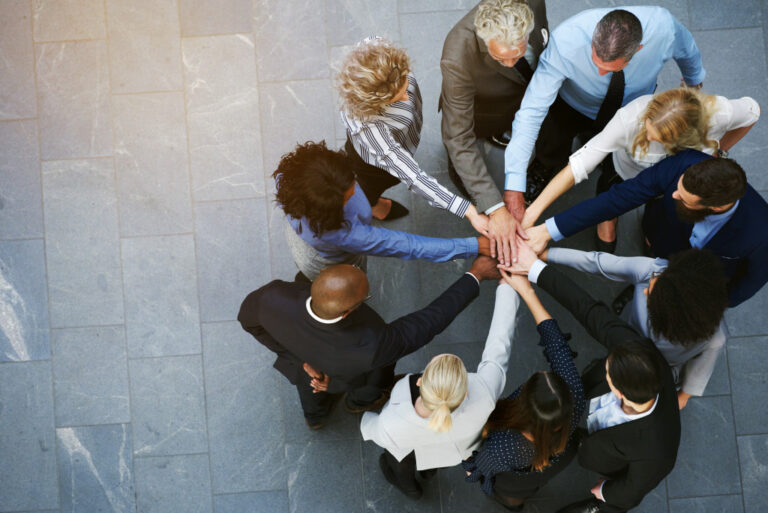 group of business people joining their hands together in a circle