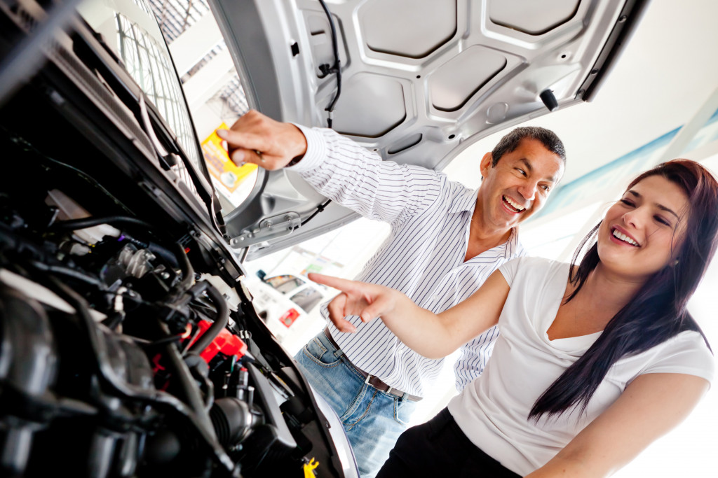 couple checking the engine before buying a car