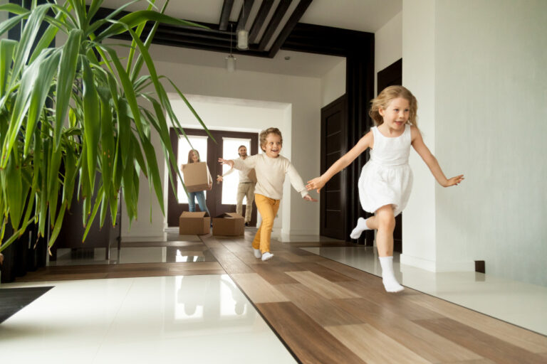 young kids happily entering a rental home with parents at the back